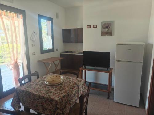a small kitchen with a table and a refrigerator at Gli Ulivi Residence in Leverano