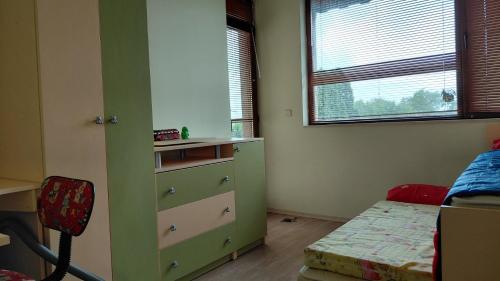 a bedroom with a green dresser and a bed at Вила Зеленка - Villa Zelenka in Bŭlgarevo