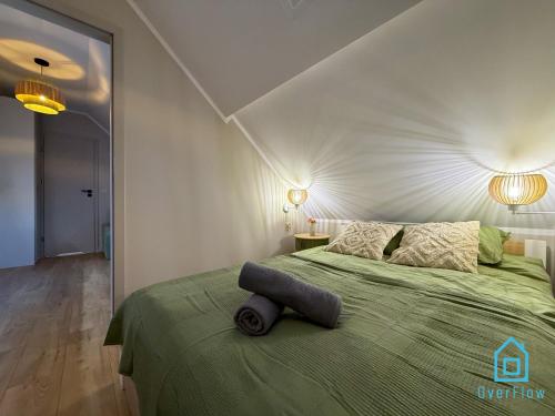a bedroom with a green bed with a white wall at Casa Verde Apartment at Old Town Gdańsk in Gdańsk