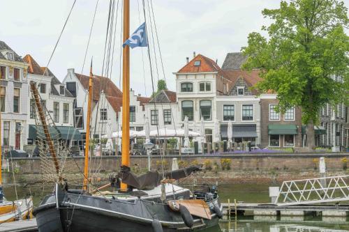 a boat is docked in the water near buildings at Job Baster Kraanplein - Het Zonnehof in Zierikzee