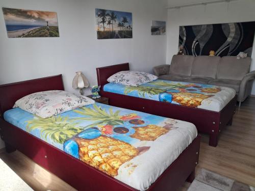 two beds in a room with a couch at Ferienwohnung Michelle in Bremerhaven