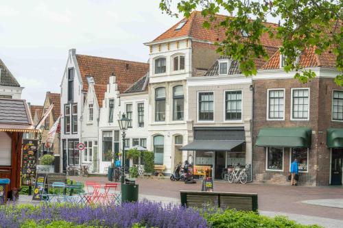 a city street with buildings and purple flowers at Job Baster Kraanplein - Het Zonnehof in Zierikzee