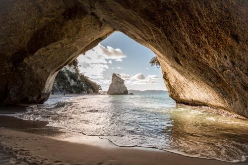 a view of the ocean from a cave on the beach at Tasman Holiday Parks - Hahei Beach in Hahei