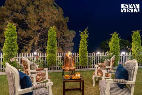 a group of chairs in a yard at night at StayVista at IRIS with Outdoor Pool & Bonfire in Dagshai