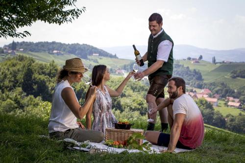 a group of people sitting on a hill drinking wine at Ratscher Landhaus in Ratsch an der Weinstraße