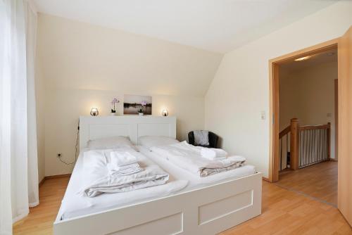 a white bed with white sheets and towels on it at Meeresbrise in Norddeich