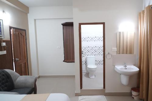 a bathroom with a toilet and a sink at Nova Saara Palace in Kannur