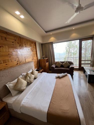 a large bedroom with a large bed and a couch at Barog Heights in Barog