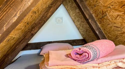 a bed with a pink blanket on top of it at Bosnian Pyramid Glamping in Visoko