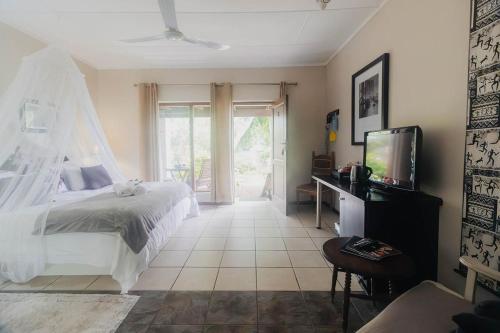 a bedroom with a bed and a tv in it at Rustic Butler B&B in White River