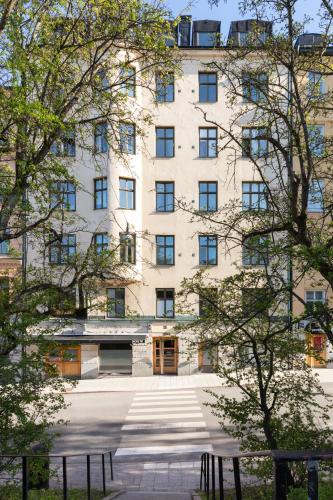 a large white building with trees in front of it at Bob W Stockholm Södermalm in Stockholm