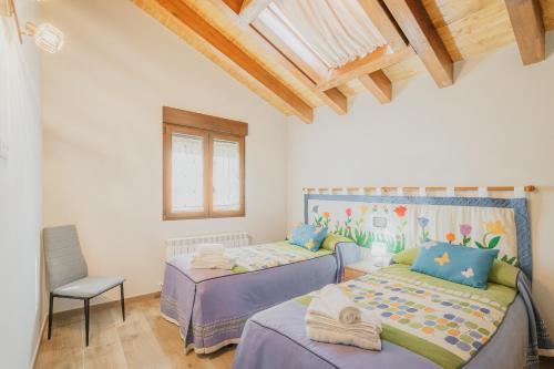 a bedroom with two beds and a chair at El Trillo in Marlín