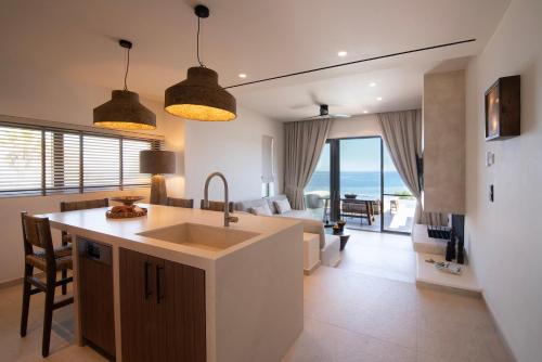 a kitchen and living room with a view of the ocean at AÁSHNA Suites and Residences in Vaia
