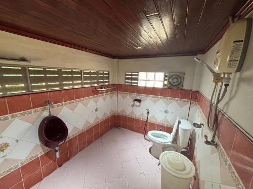 ein Badezimmer mit zwei Toiletten und einem Urinal in der Unterkunft SP Home at Maesot in Mae Sot