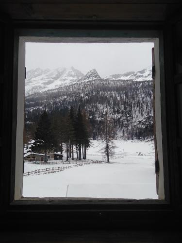 a window with a view of a snow covered mountain at Chalet del Lago in Ceresole Reale