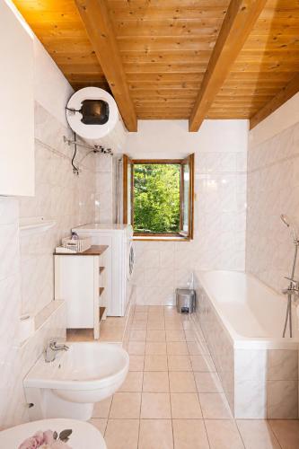 a bathroom with a tub and a toilet and a sink at Maso Simoni - Bazzanella in Piscine di Sover