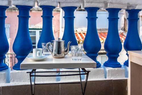 a table with a tea kettle and glasses on a balcony at Anjo Azul in Lisbon