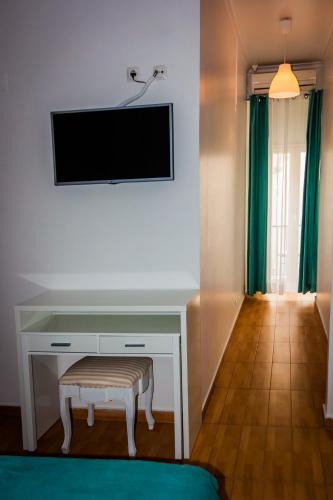 a room with a desk with a tv and a stool at Anjo Azul in Lisbon