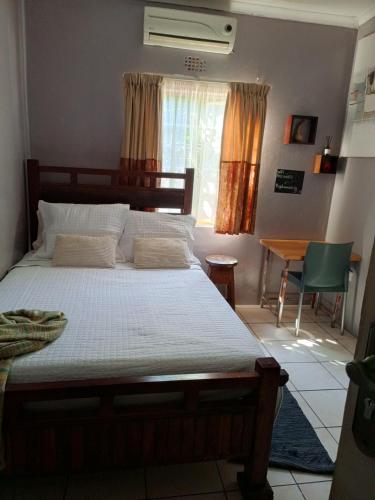 a bedroom with a bed and a table and a window at 1054 Holiday Home in Kasane Airport