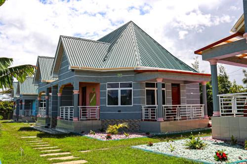 a small blue house with a green roof at JK Maasai Hotel in Wasso