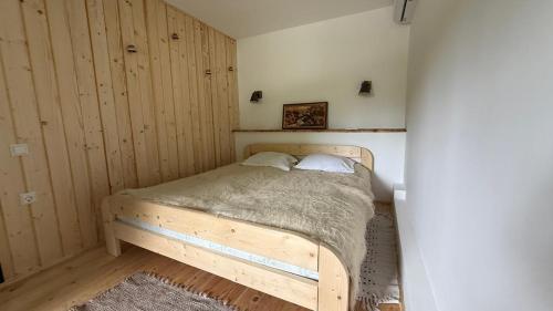 a bedroom with a wooden bed with two pillows at Три сосни in Kosiv