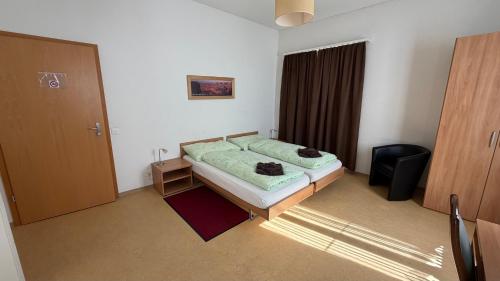 a small bedroom with a bed and a door at Adler in Linthal