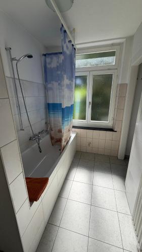 a bathroom with a shower and a tub and a window at Adler in Linthal