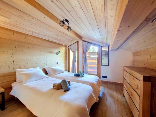 a large white bed in a room with wooden ceilings at Gervonne 2 in Morzine