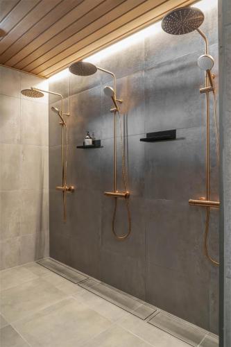 a shower in a bathroom with three lights on the wall at Pellinge Marina in Porvoo