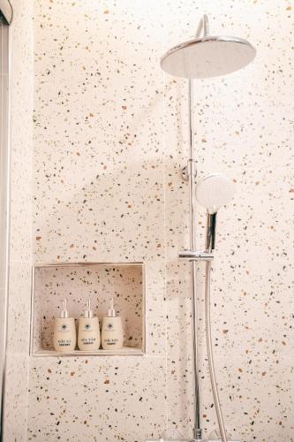 a bathroom with a shower with four bottles on a shelf at Sunset Samson Hotel in Sầm Sơn