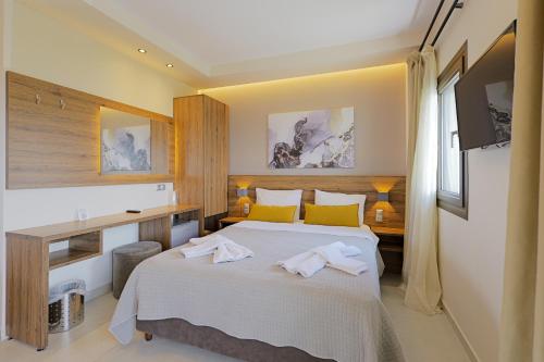 a bedroom with a bed with towels on it at Sunset Hotel in Ouranoupoli