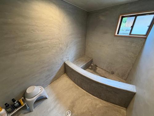 a small bathroom with a tub and a window at 和風アンドラン in Minamiawaji
