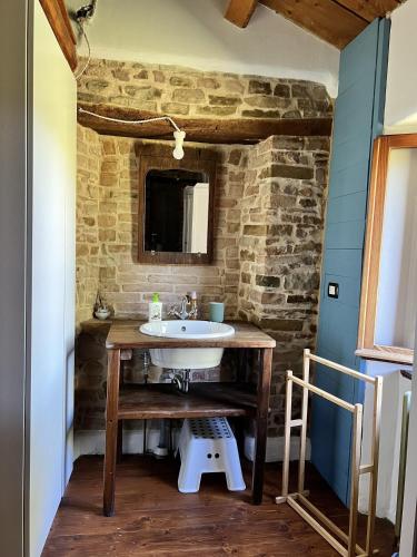 a bathroom with a sink and a stone wall at The Bookhouse Home Bb in Poggio San Marcello 