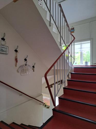 a staircase with red carpet and white walls and a stair case at Elvebakk Bed & Breakfast in Reed
