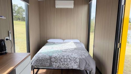 a small bedroom with a bed in a trailer at Oscars Retreat 1 by Tiny Away in Raworth