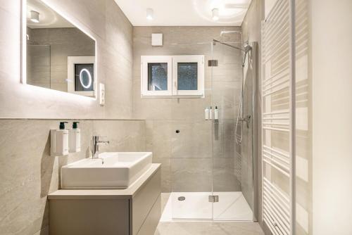 a white bathroom with a sink and a shower at Ferienwohnung Sigi in Traben-Trarbach