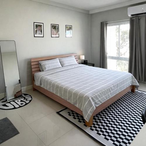 a bedroom with a large bed and a window at Mayeen cat hotel in Chiang Mai