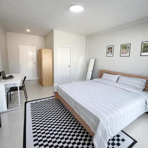 a bedroom with a large bed with a black and white rug at Mayeen cat hotel in Chiang Mai