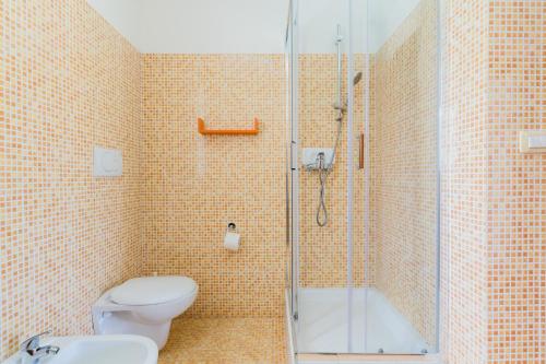 a bathroom with a toilet and a glass shower at Residence Quattro Colonne in Santa Maria al Bagno
