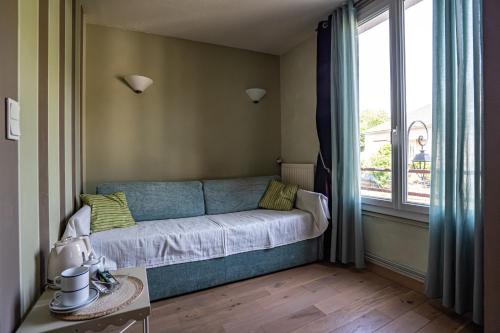 a blue couch in a room with a window at Beauséjour in Calvinet