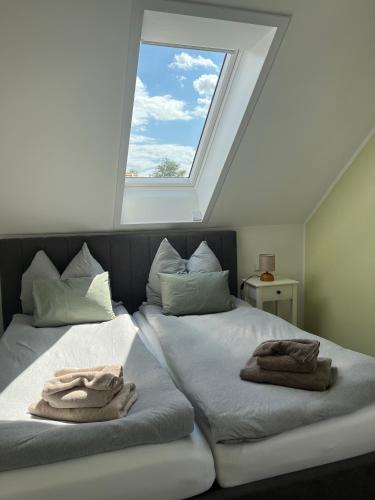two beds in a room with a window at Haus Wally - Ferienwohnungen in Klitten