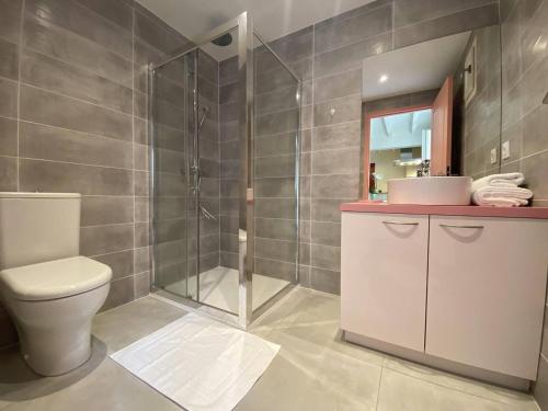 a bathroom with a toilet and a shower and a sink at Le réveil des oiseaux in Taillet
