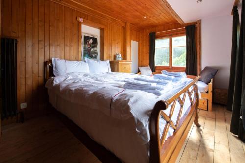 a bedroom with a large bed in a wooden room at Le Bois-Gentil in Gryon