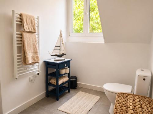 a bathroom with a white toilet and a window at Appartement calme et spacieux, tout équipé in Saint-Quentin