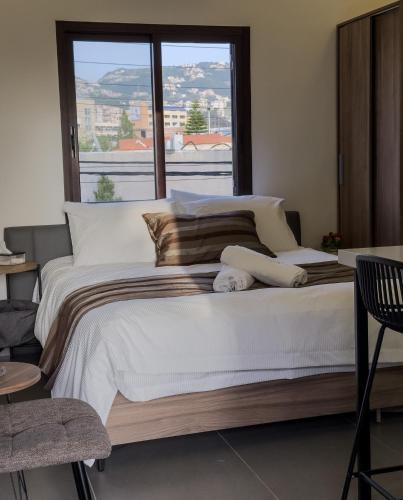 a bedroom with a large bed with a large window at Railway Studio 2 - Modern Studio in Byblos - Easy city Access in Jbeil