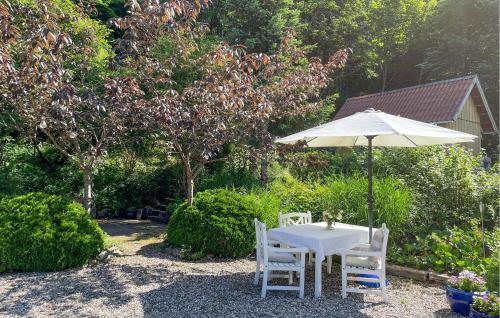 a white table and chairs with an umbrella at 3 Bedroom Beautiful Home In Bryrup in Bryrup