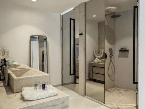 a bathroom with a shower and a tub and a sink at Myconian Villa Collection - Preferred Hotels & Resorts in Elia Beach