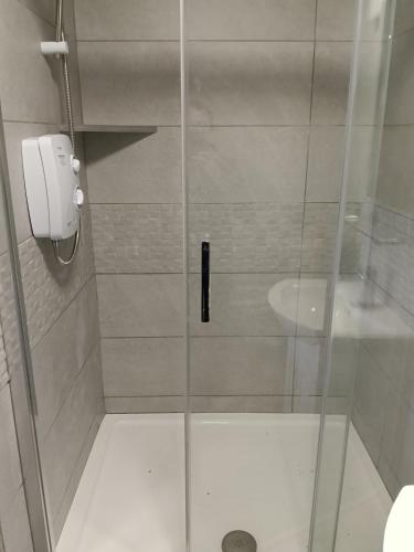 a shower with a glass door and a sink at Liam's Cottage Bed and Breakfast in Lisdoonvarna