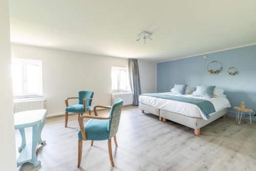 a bedroom with a bed and a table and chairs at Gîte Athois la campagne in Ath