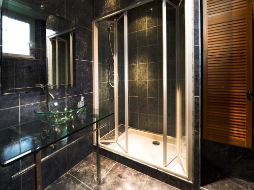 a glass shower in a bathroom with a sink at Chambres d'hôtes & Gîtes La Paysanne in Fresnes-en-Woëvre